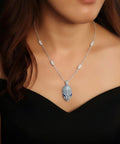 Necklace with a detailed pendant on a model against a dark background