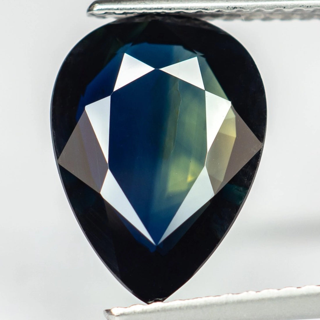 deep greenish blue pear sapphire unheated natural corundum top view tweezers