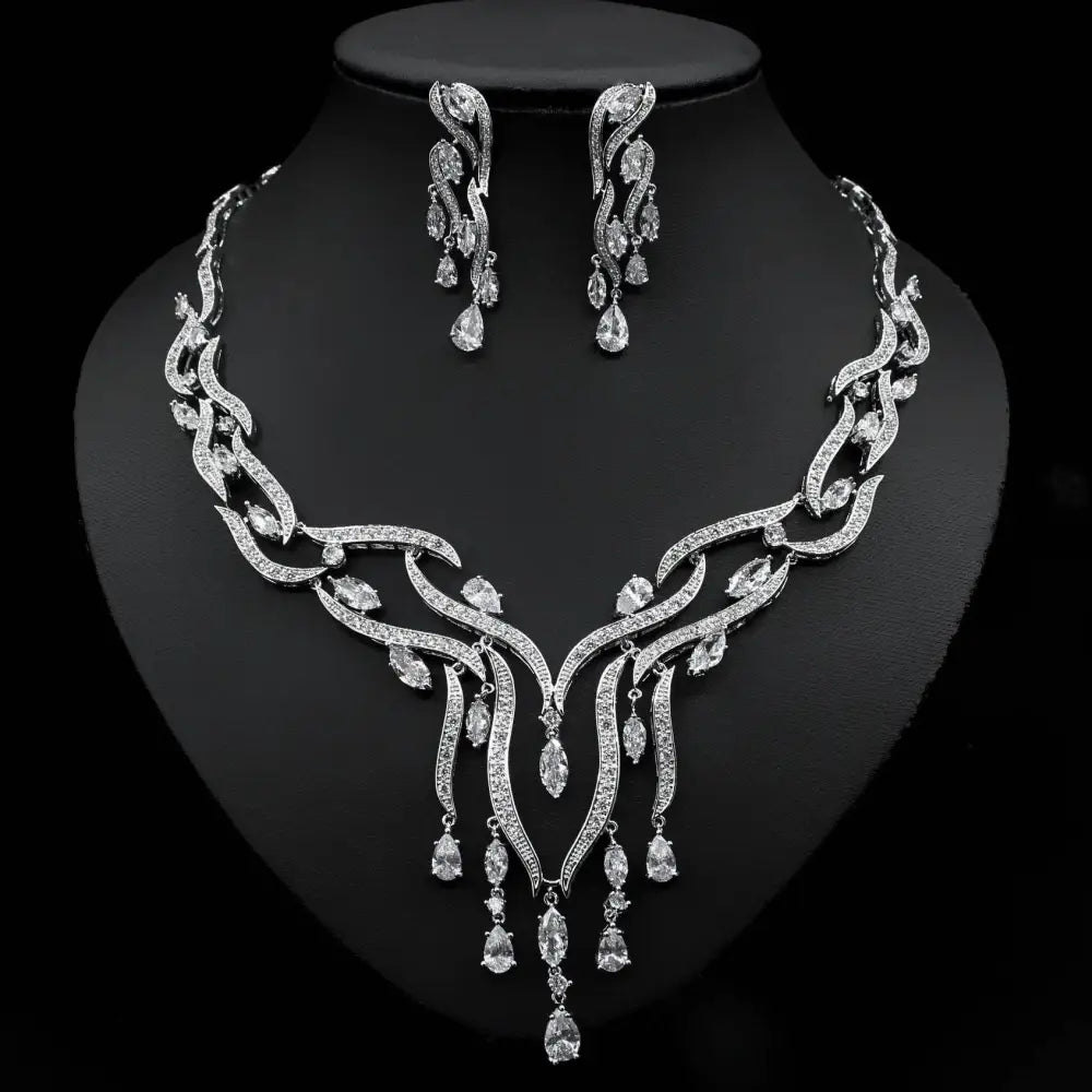 Jewelry set with necklace and earrings featuring green gemstones on a black background
