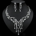 Silver necklace and earrings set on a black background