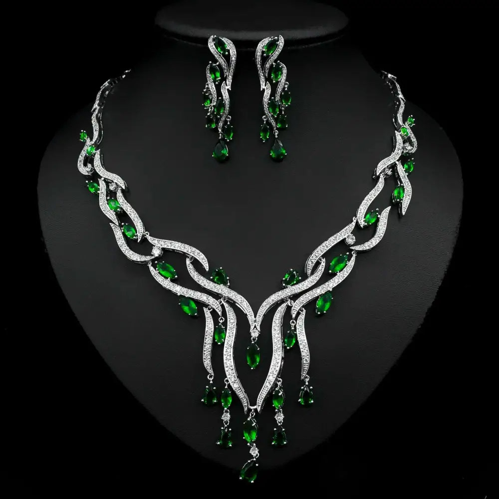 Jewelry set with necklace and earrings featuring green gemstones on a black background