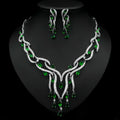 Jewelry set with necklace and earrings featuring green gemstones on a black background