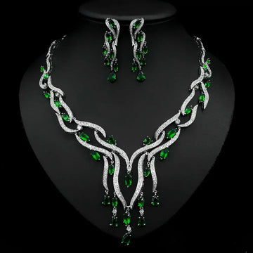 Jewelry set with necklace and earrings featuring green gemstones on a black background