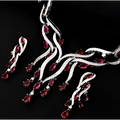 Silver necklace with red gemstones on a black background